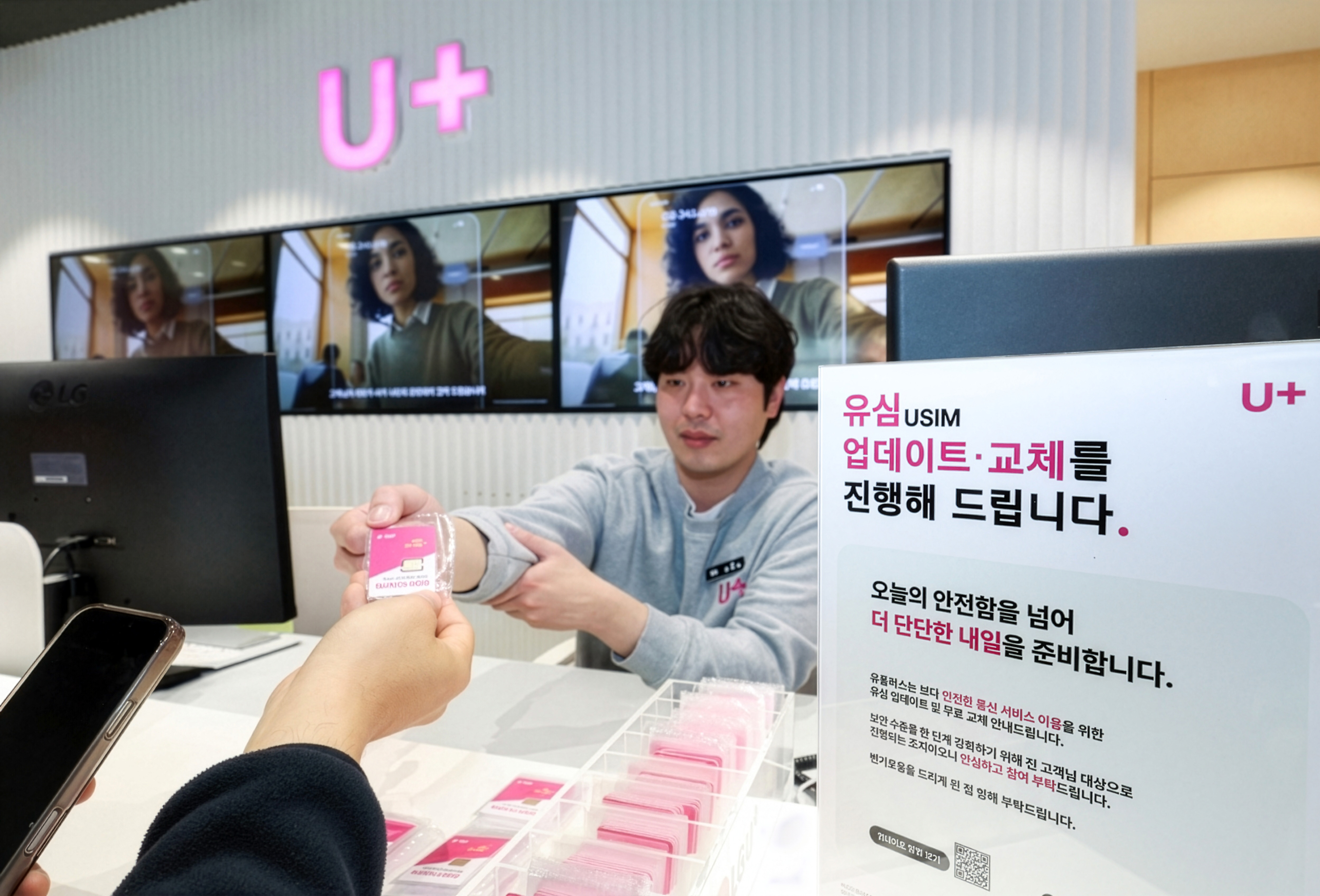 LG유플러스 공식 매장에서 직원이 고객에게 무료 유심 카드를 전달하는 실제 모습