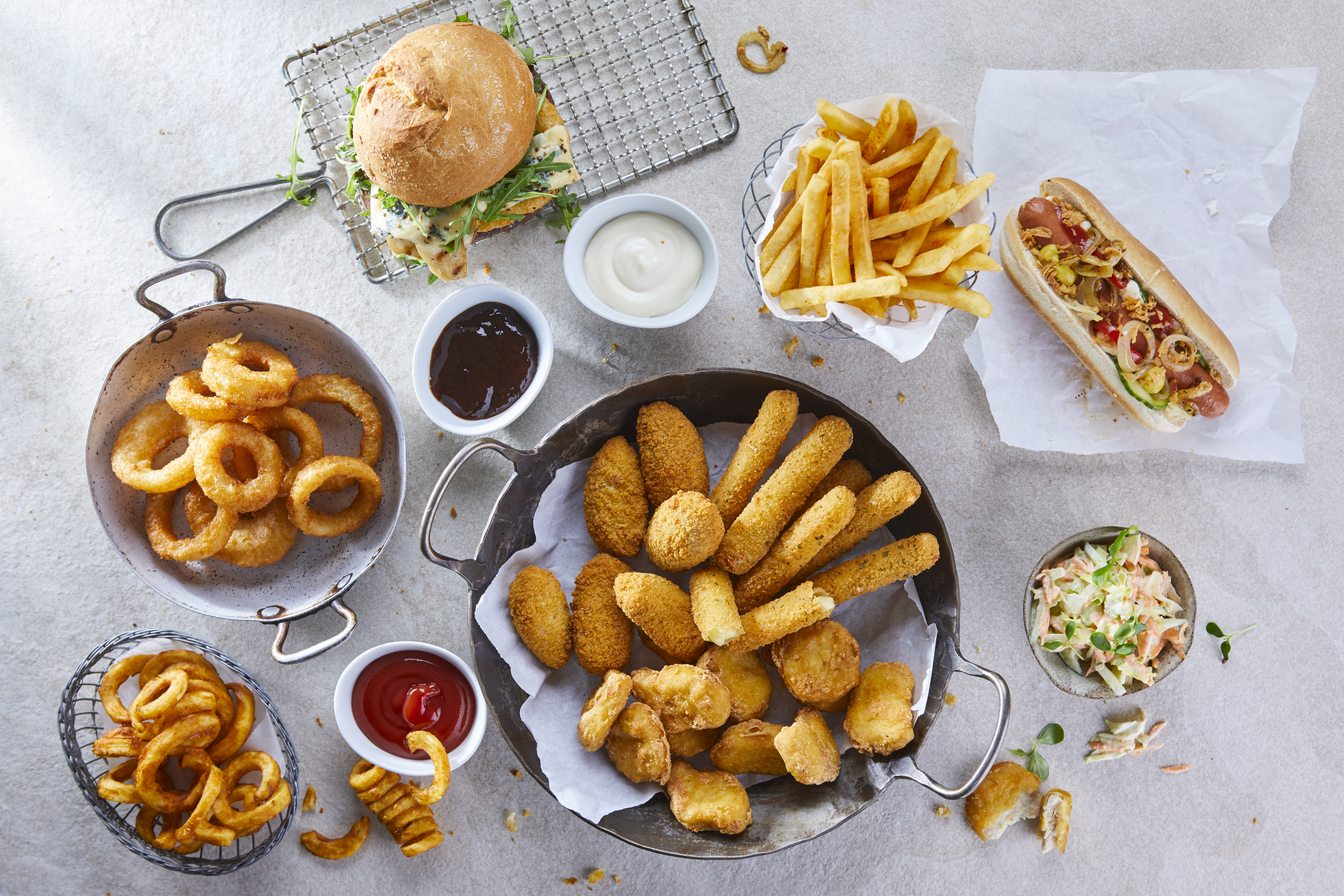 Verschiedene Fast Food Snacks mit Dips, Pommes Frites und Coleslaw