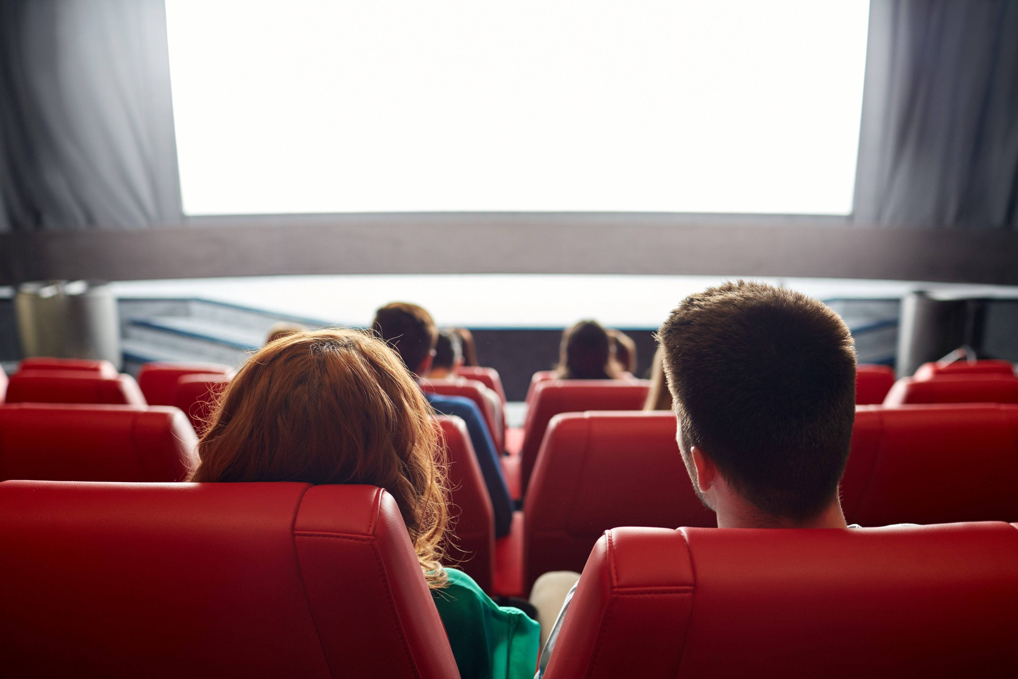 Happy couple watching movie in theater or cinema